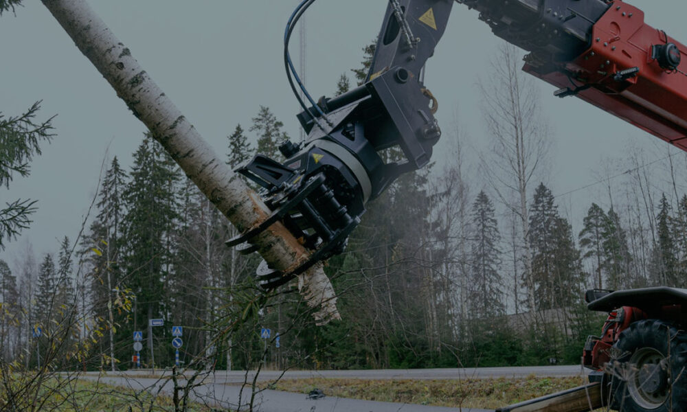 JAK-300R energiakoura kiinnitettynä kurottajaan, pitämässä kiinni isosta puunrungosta.